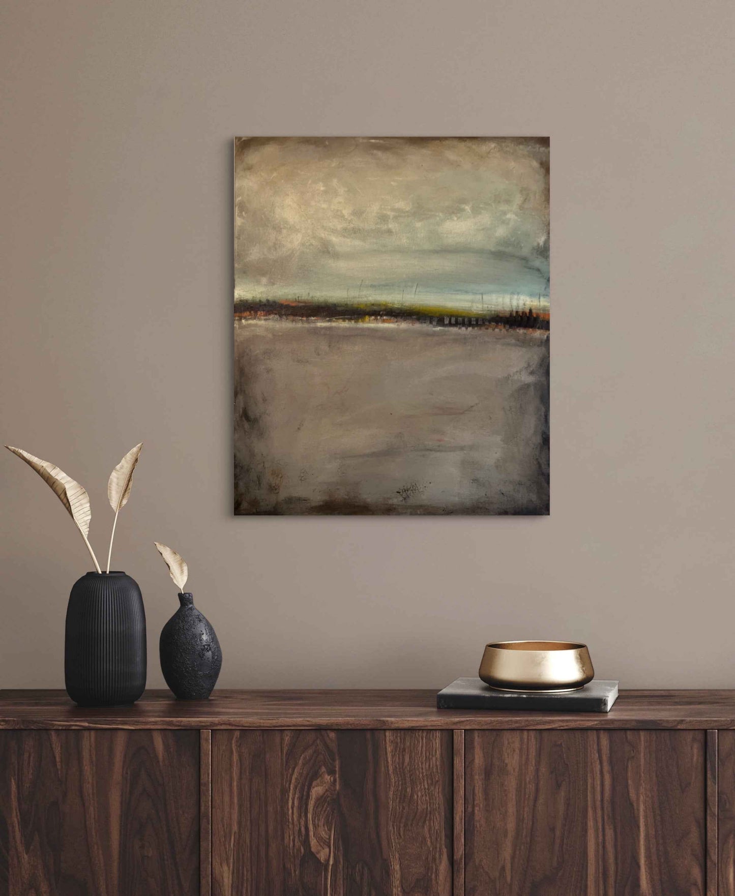 Muted abstract landscape artwork displayed in a minimalist interior, emphasizing mood and emotional restraint