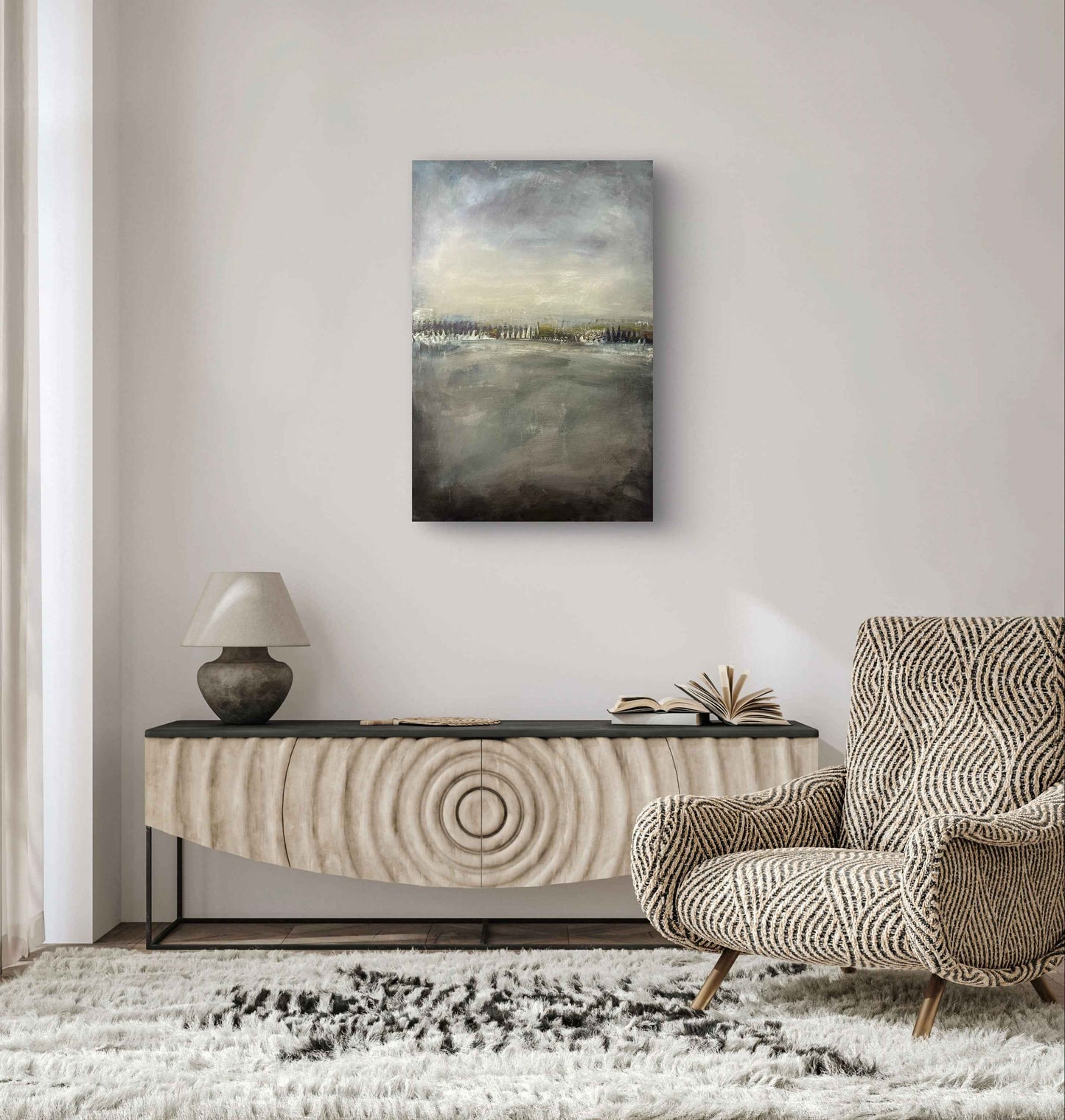 Muted abstract landscape artwork displayed in a minimalist interior, emphasizing stillness and atmospheric depth