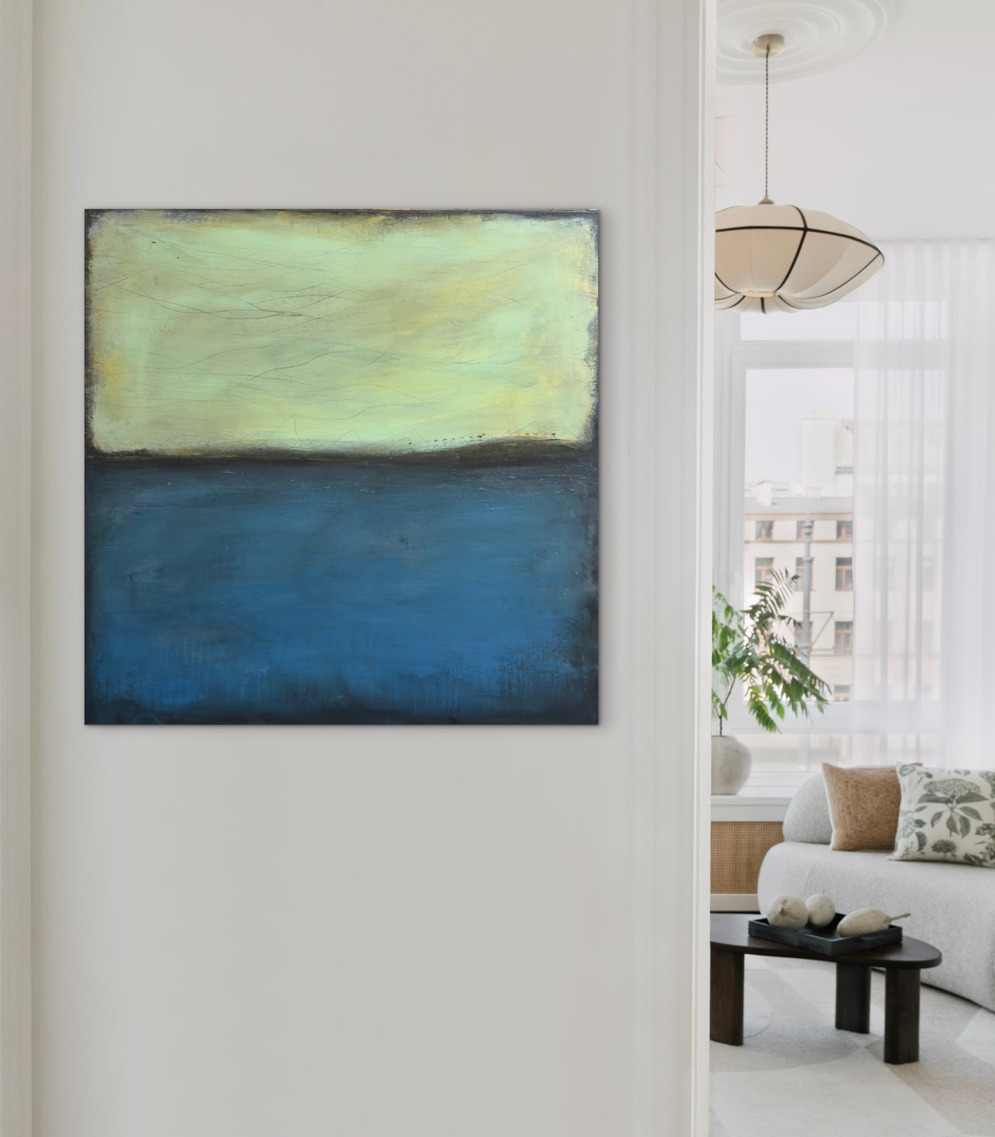 The Only Thing I'm Missing, 30x30" abstract painting by Michelle Ramos displayed in a bright modern interior. Chartreuse and navy blue artwork hanging on a white wall beside a window.
