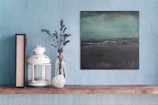 Wander 12x12 original abstract painting displayed in a modern interior, showing its cool teal and grey palette and soft atmospheric texture as wall art within contemporary décor.